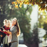 Mother and little daughter playing together in a park