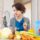 beautiful woman cooking vegetarian lunch in  kitchen